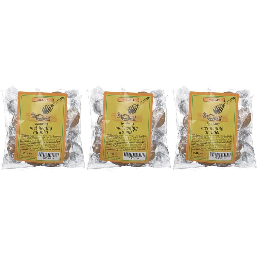 Trois paquets de bonbons. Chaque paquet a une étiquette jaune avec du texte et un symbole de rayon de miel. Les bonbons sont emballés individuellement.