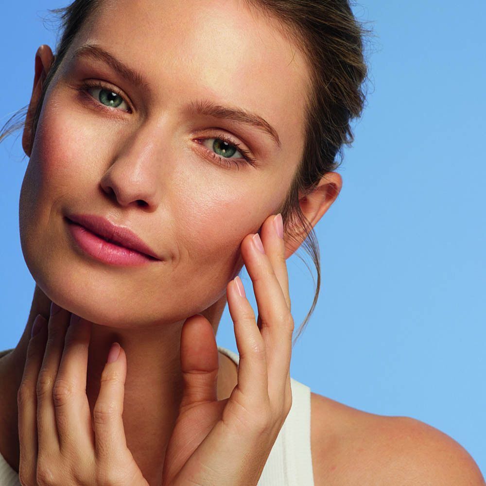 Portrait d'une femme avec soin de la peau. Fond bleu.
