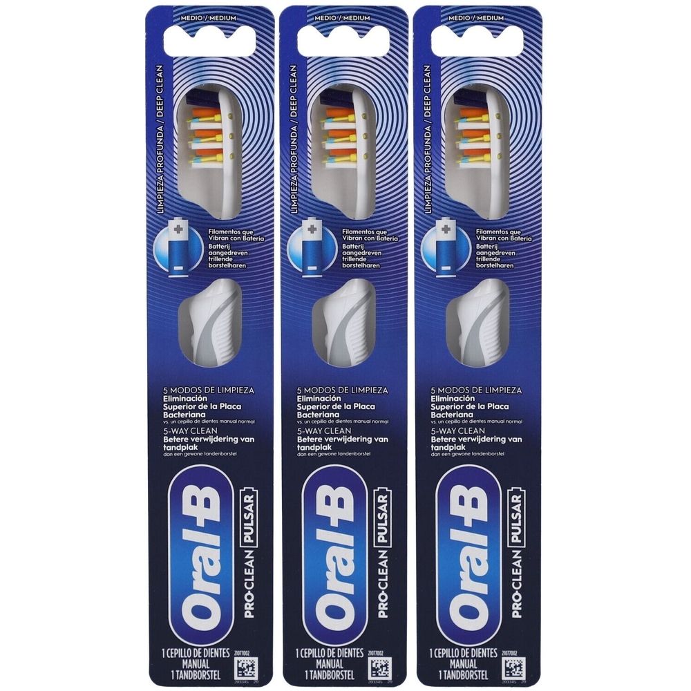 Drie tandenborstels in blisterverpakking. Witte borstelkoppen met oranje haren. Blauwe verpakking met productinformatie.