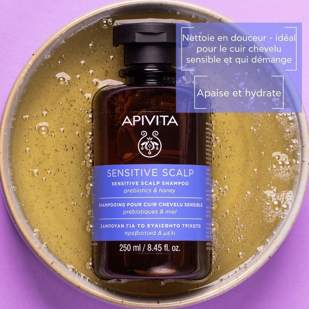 Flacon de shampooing dans un bol avec liquide. Texte: Apivita Sensitive Scalp Shampoo.