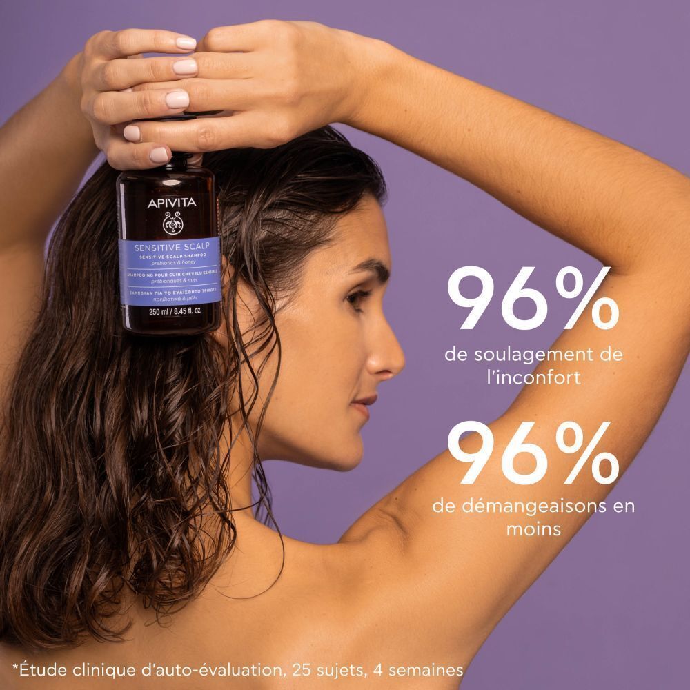 Femme tenant un flacon de shampooing. Texte: Apivita Sensitive Scalp Shampoo. 96% de soulagement.