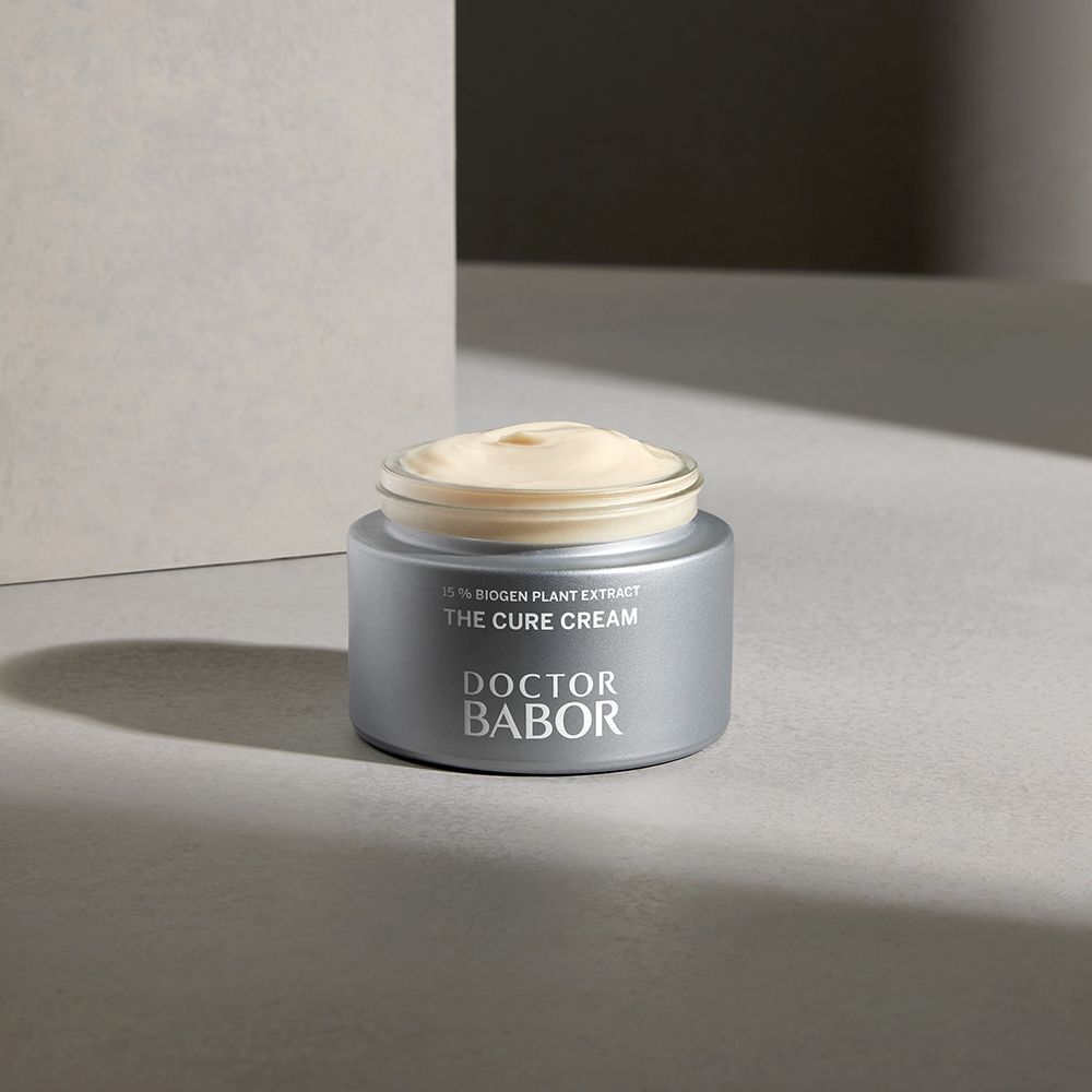 Zilverkleurige pot met crème, tekst THE CURE CREAM en DOCTOR BABOR.