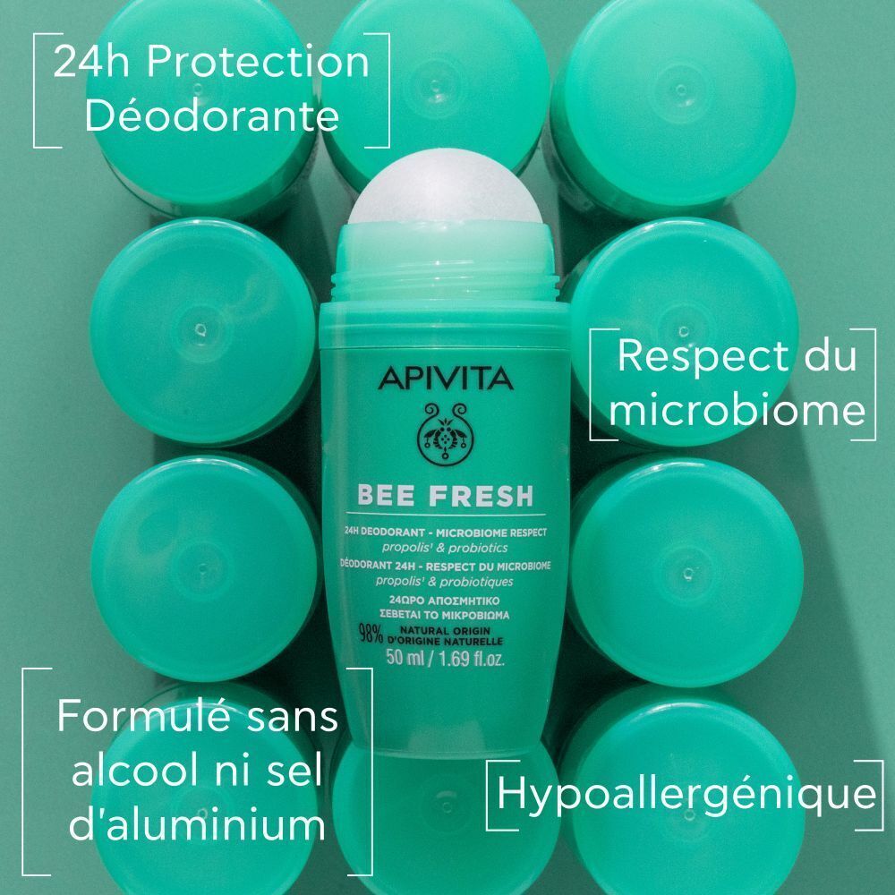 Déodorant roll-on vert entouré de bouchons verts. Inscription : Apivita, Bee Fresh, 24h Déodorant. Texte : sans alcool, sans sels d'aluminium.
