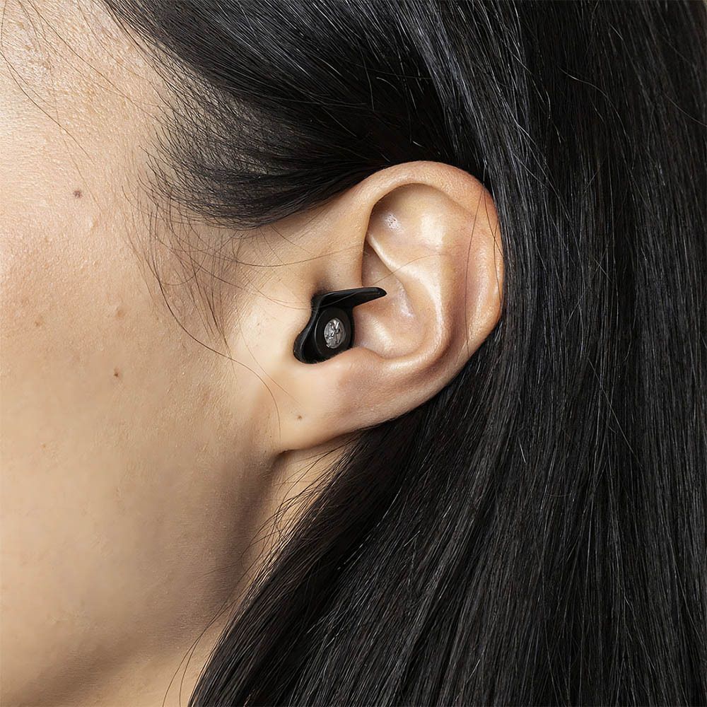 Bouchon d'oreille dans l'oreille d'une personne. Bouchon d'oreille noir avec filtre visible.