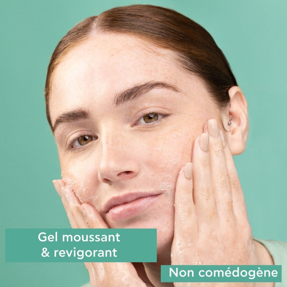 Femme se lave le visage avec gel moussant. Texte: Non comédogène.