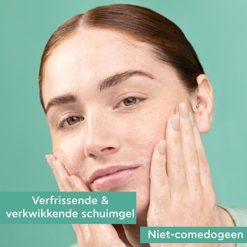 Vrouw wast gezicht met schuimende gel. Tekst: Niet-comedogeen.