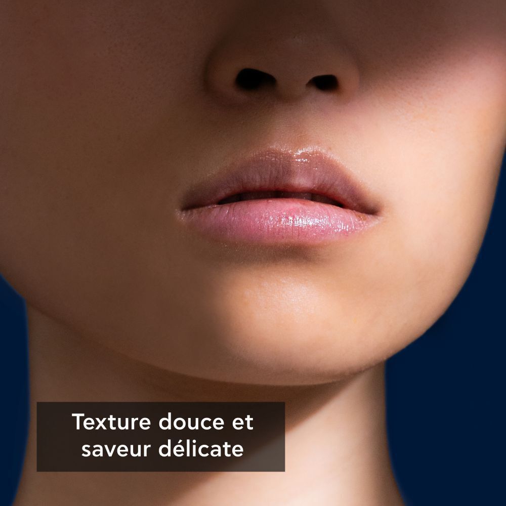 Gros plan sur les lèvres. Peau avec ombre. Texte : Texture douce et saveur délicate.