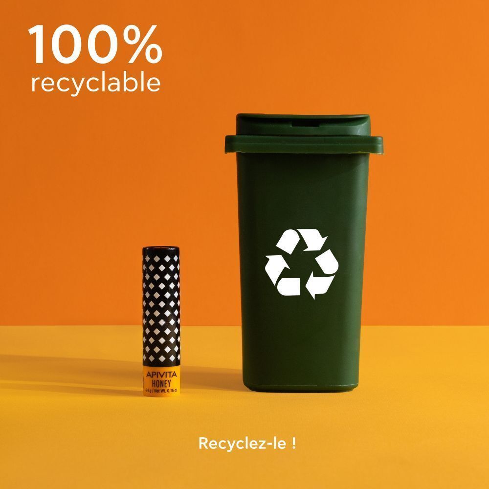 Stick à lèvres à côté d'une poubelle verte. Texte : "100% recyclable".