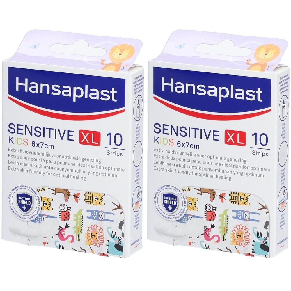 Twee verpakkingen Hansaplast Sensitive Kids XL pleisters. Opschrift: Sensitive XL, 10 strips, 6x7cm. Verpakking met kinderlijk design en leeuw.