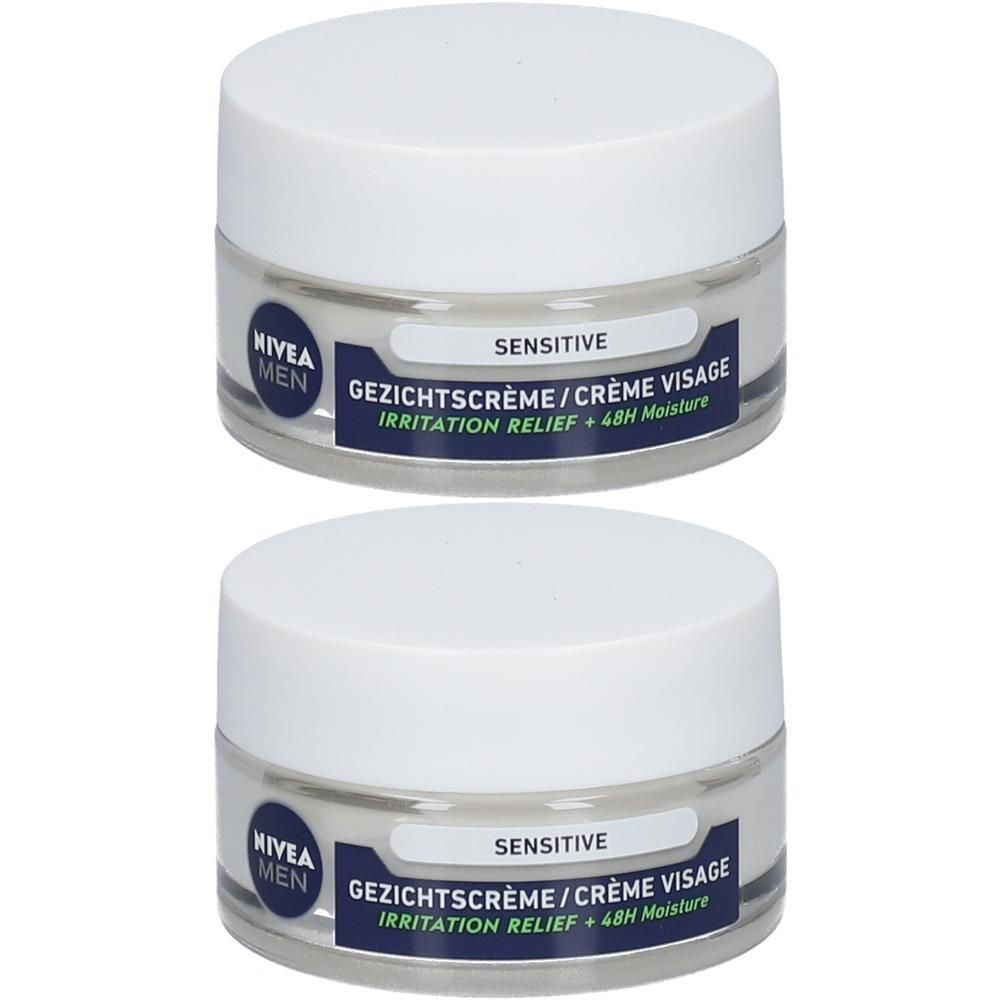 Deux pots de crème visage Nivea Men Sensitive. Couvercles blancs, pots transparents avec étiquettes bleues. Inscription : Sensitive, Crème Visage.