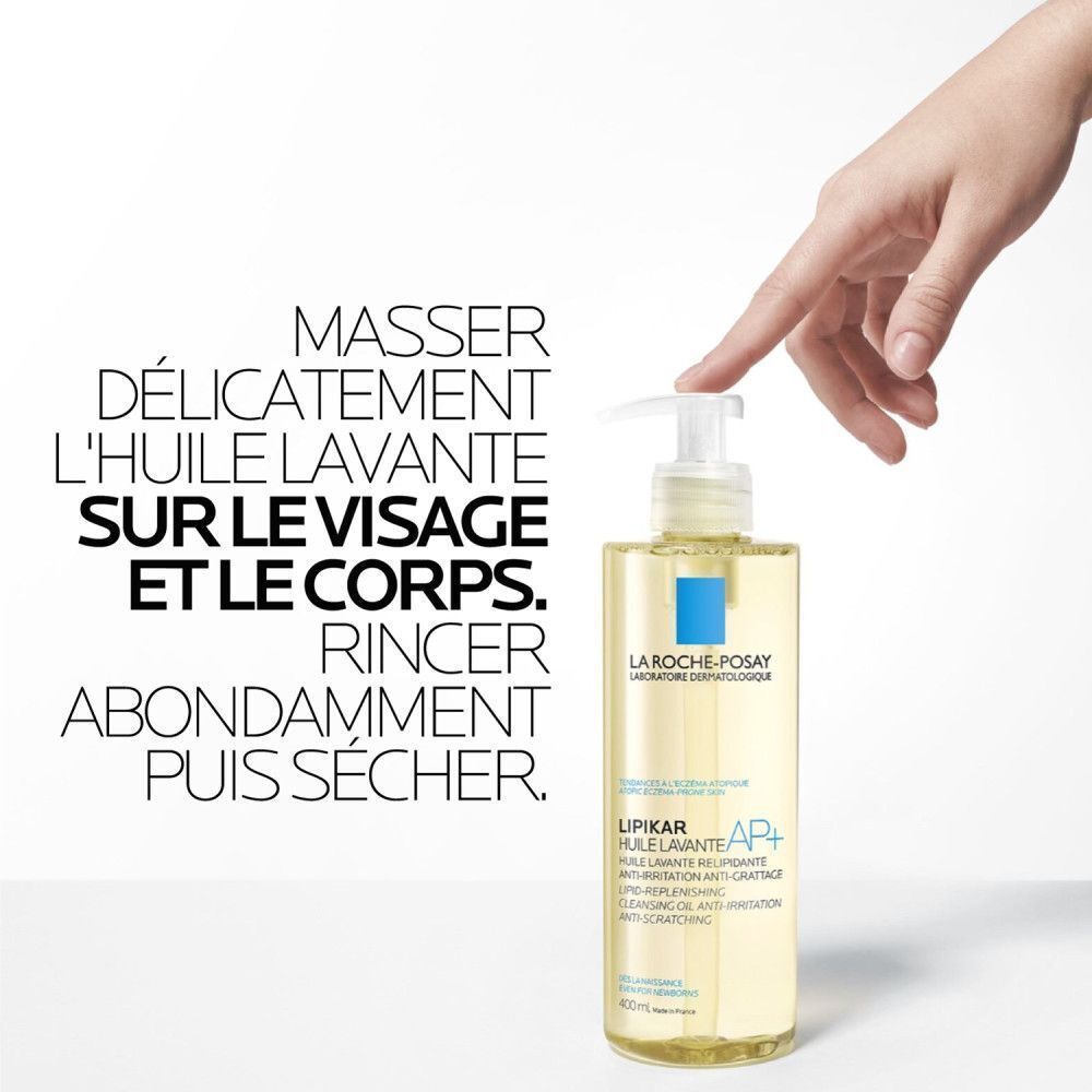 Main touchant un flacon de La Roche-Posay Lipikar AP+ Huile Lavante. Texte: instructions.