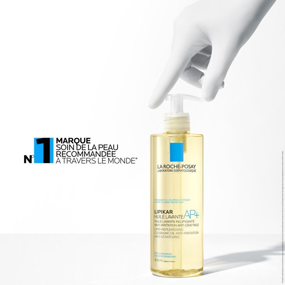 Main touchant un flacon de La Roche-Posay Lipikar AP+ Huile Lavante. Texte: N°1 soin peau.