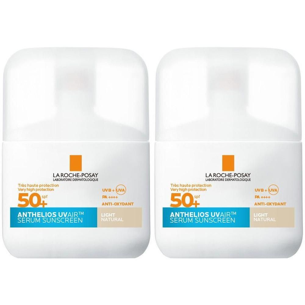 Twee flessen La Roche-Posay Anthelios UVAIR SPF50+ serum. Witte flessen met oranje accenten.