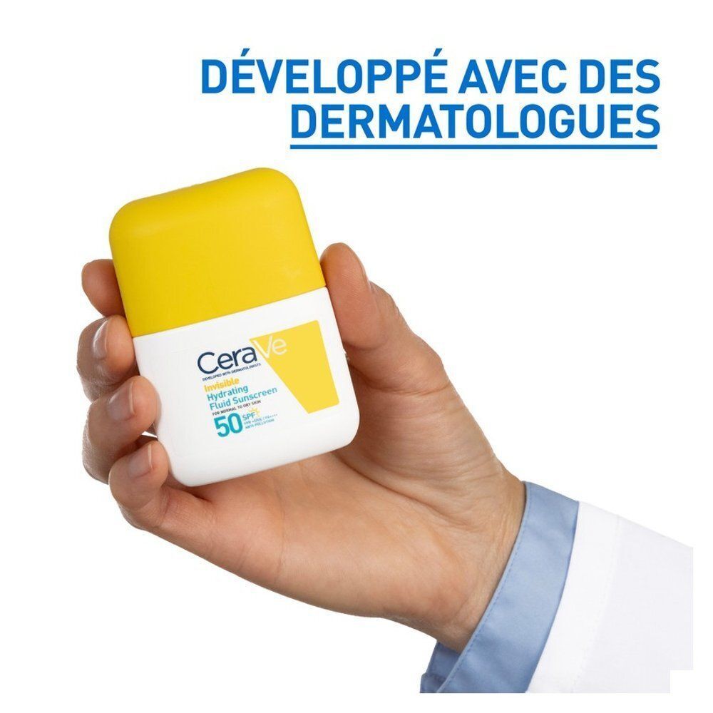 Une main tient un flacon blanc avec un bouchon jaune. Le flacon porte l'inscription "CeraVe Hydrating Fluid Sunscreen 50".