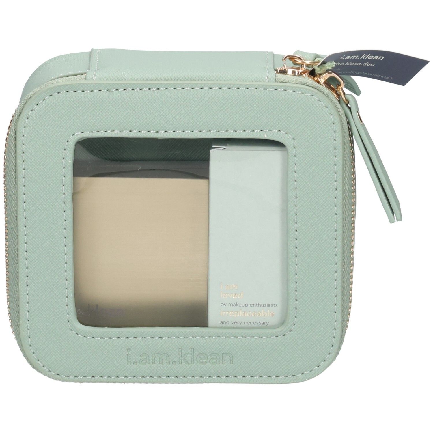 Trousse de toilette carrée vert clair avec fermeture éclair et fenêtre transparente. Contient un produit beige et un produit vert clair. Étiquette.
