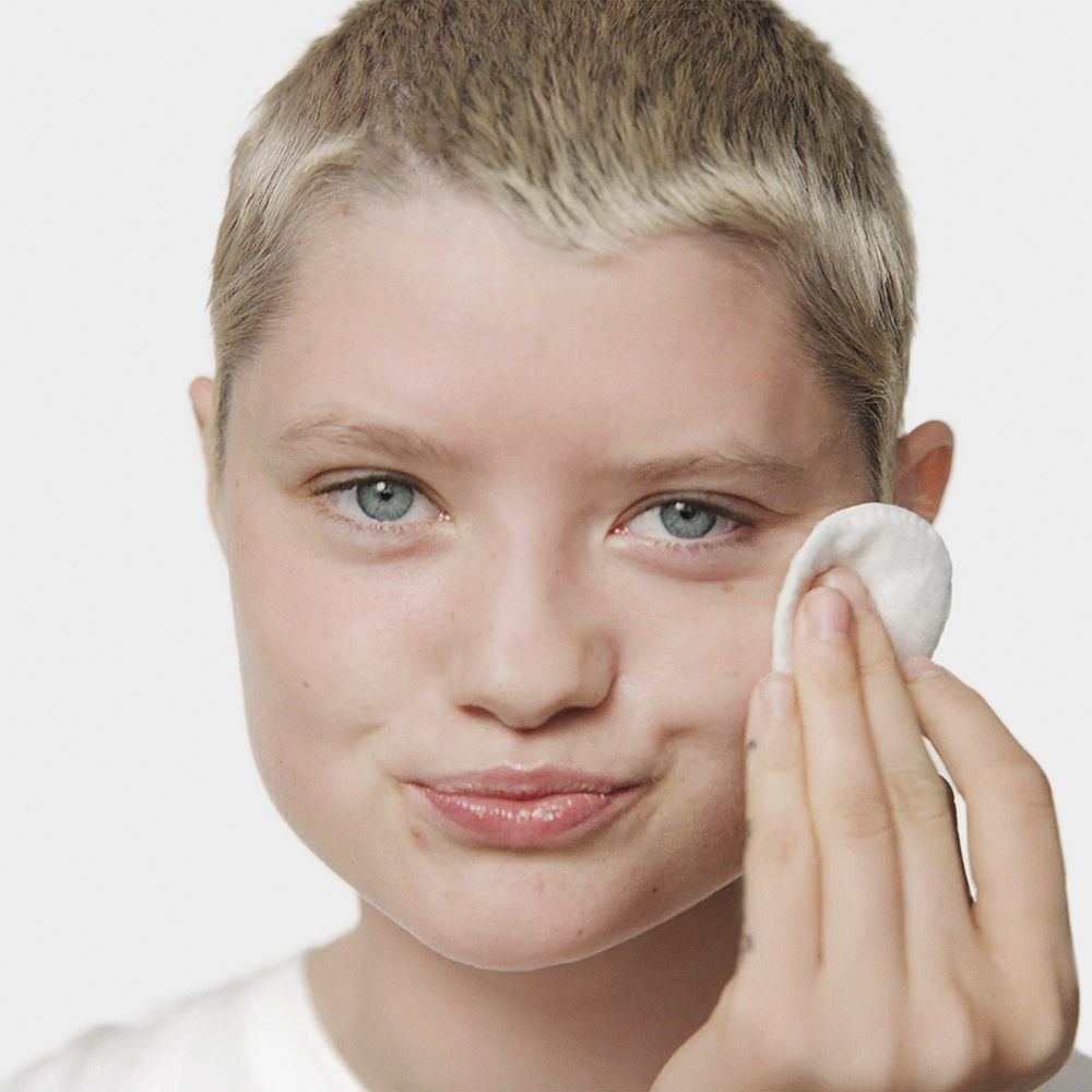 Een persoon gebruikt een wattenschijfje met Clinique Clarifying Lotion.