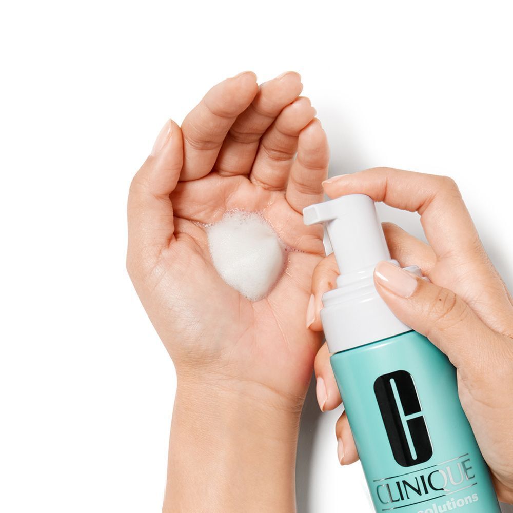Schuim van CLINIQUE Anti-Blemish Solutions™ Cleansing Foam in een hand gespoten.