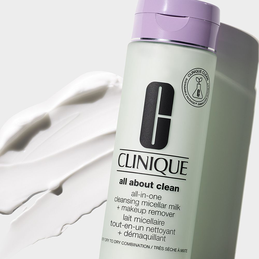 Une bouteille de Lait Micellaire Nettoyant Tout-en-un Clinique avec bouchon violet, à côté de crème blanche.
