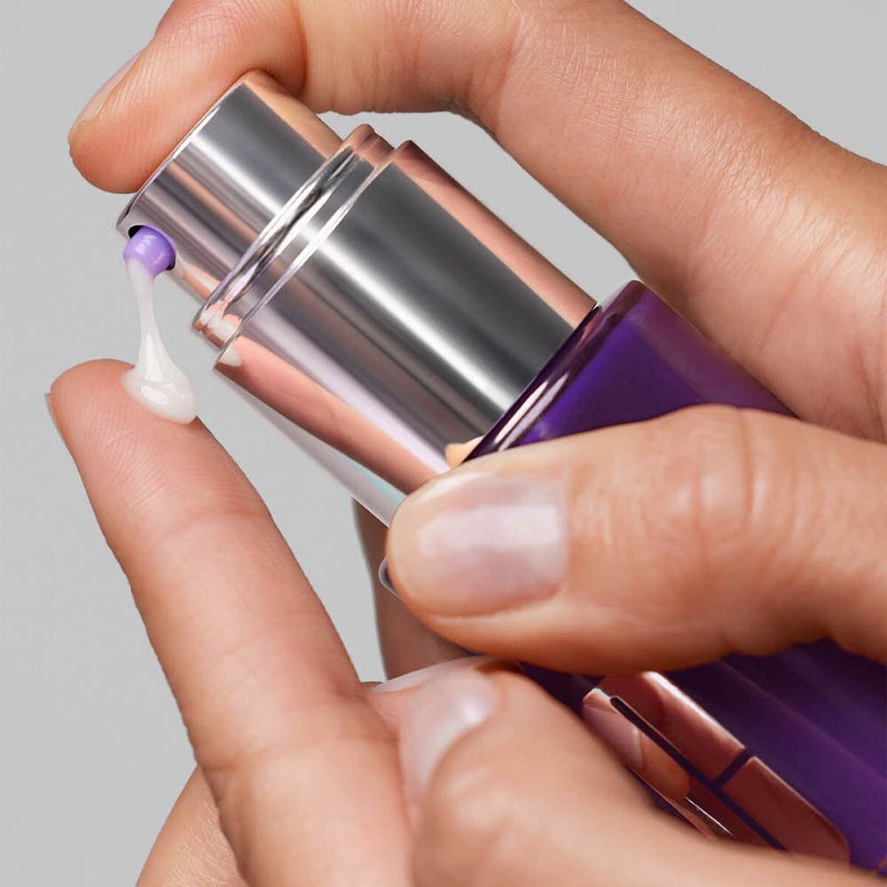 Une main presse du sérum d'un flacon violet. Pompe argentée. Texte: Clinique Smart Clinical Repair, sérum anti-rides.