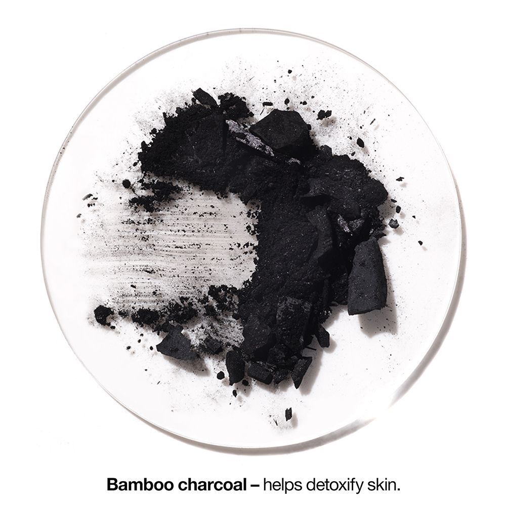 Morceaux de charbon de bambou sur une surface ronde. Texte : Charbon de bambou – aide à détoxifier la peau.