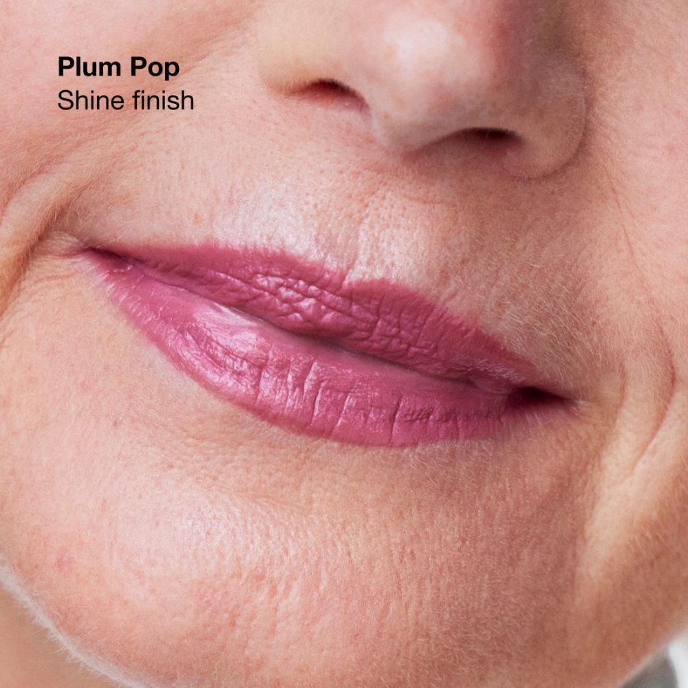Close-up van een mond met Clinique Pop lipstick Soft Plum Pop, glanzende finish.