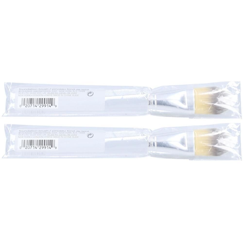 Twee Clinique foundation kwasten met zilverkleurige handvatten en crèmekleurige borstels.