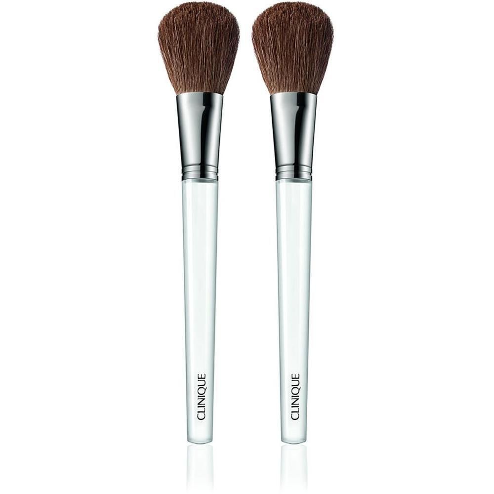 Twee poederkwasten met bruine haren, zilveren hulzen en transparante handvatten. CLINIQUE staat op de handvatten.