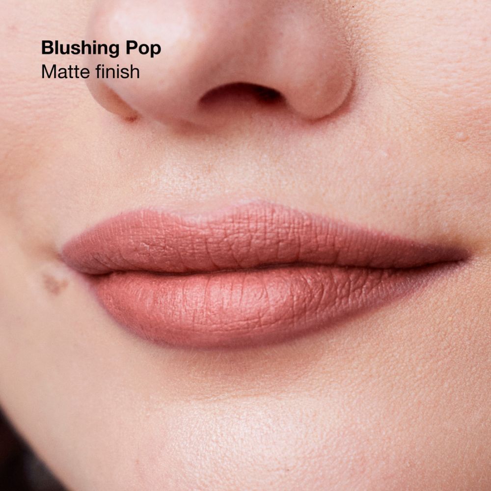 Lèvres et nez d'une femme portant le rouge à lèvres mat Blushing Pop.