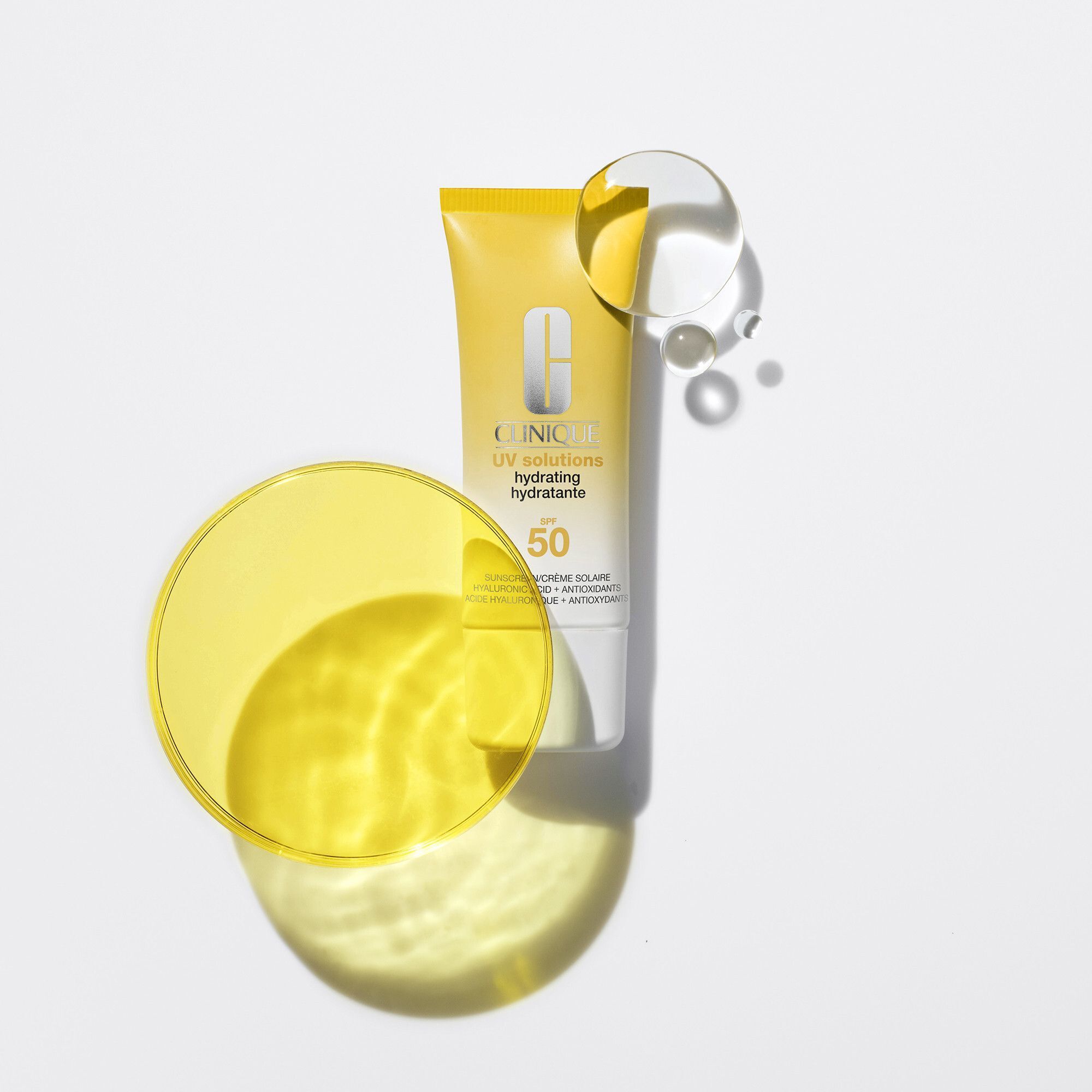 Tube de crème solaire avec éléments jaunes et transparents. Marque Clinique. SPF 50.