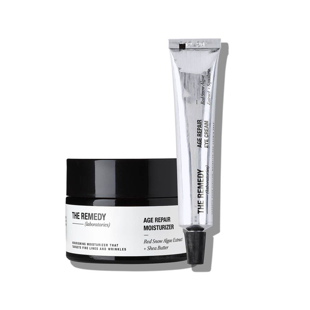 Ensemble The Remedy Laboratories. Comprend un pot de crème noir et un tube argenté. Le pot indique "AGE REPAIR MOISTURIZER".