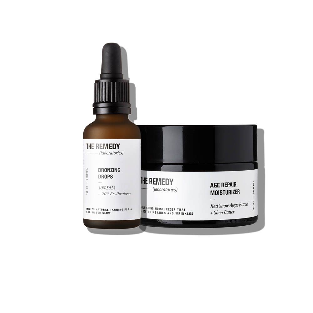 Twee cosmetische producten: een bruine fles met druppelaar en een zwarte pot. Opschrift: THE REMEDY.