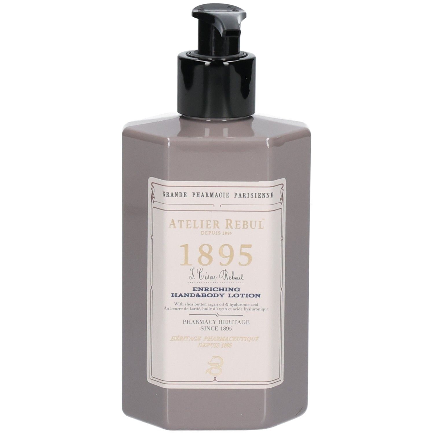 Grijze, zeshoekige fles met zwarte pomp. Etiket met tekst: Atelier Rebul 1895, hand- en bodylotion. Apotheeklogo.