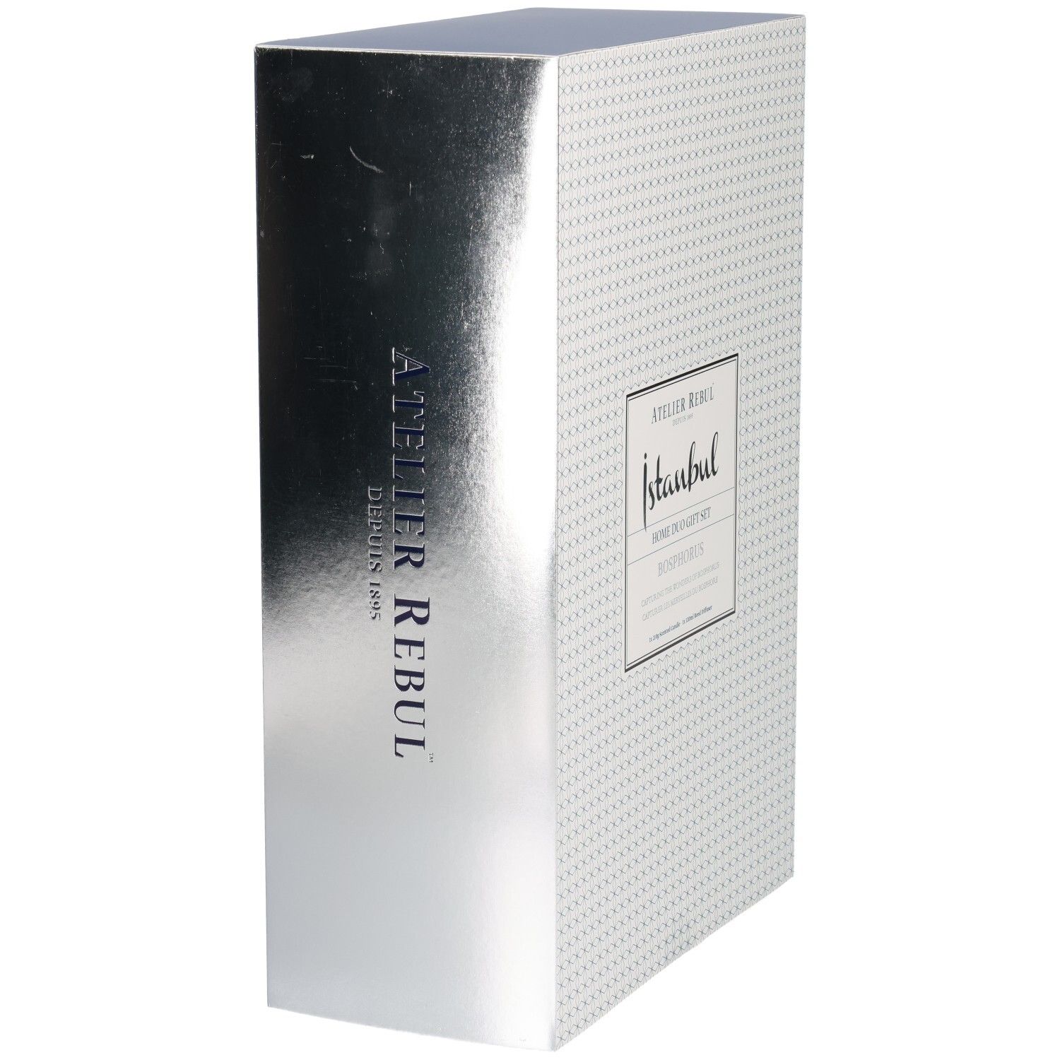 Zijaanzicht van een cadeaubox met zilveren metallic afwerking en verticale Atelier Rebul tekst.
