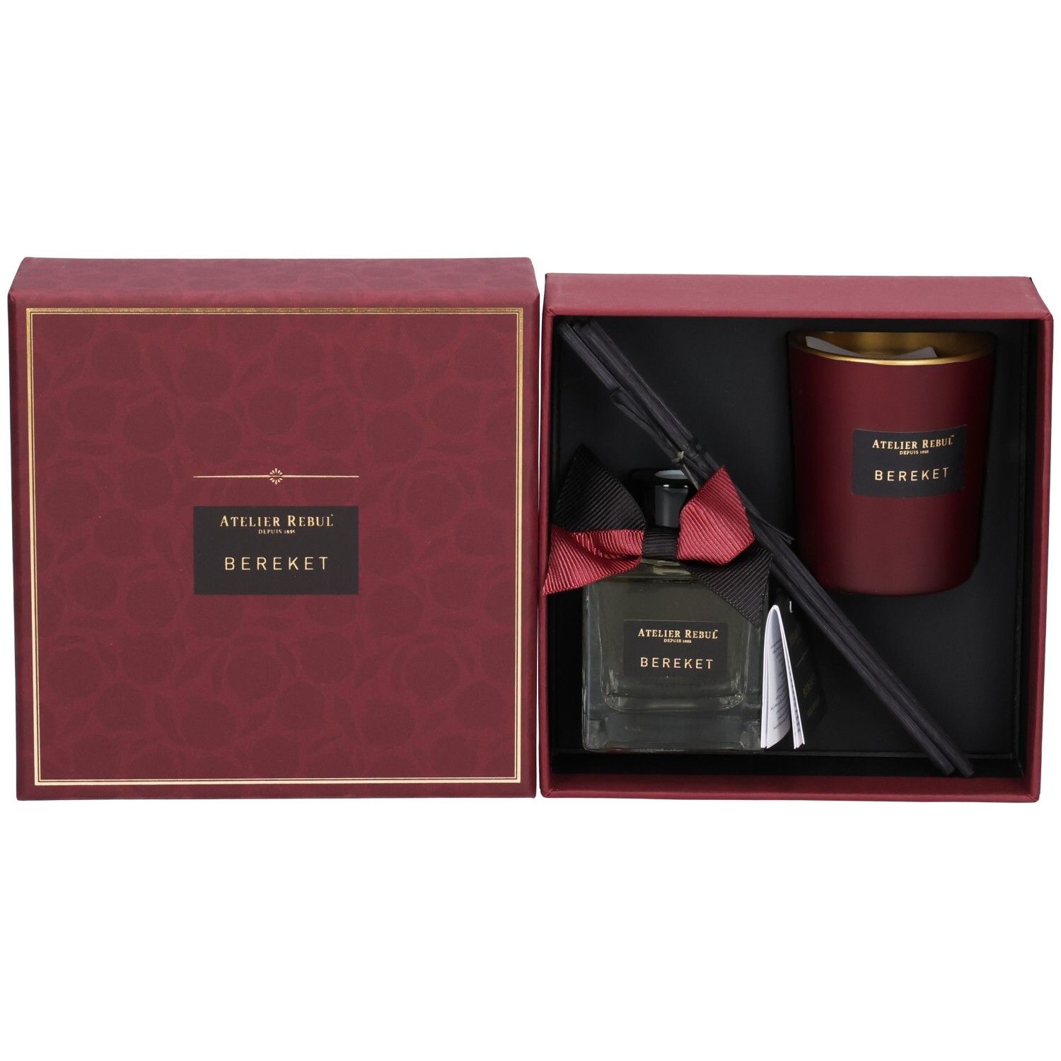 Coffret cadeau ouvert avec flacon de parfum, bougie et bâtonnets diffuseurs. Éléments rouges et noirs.