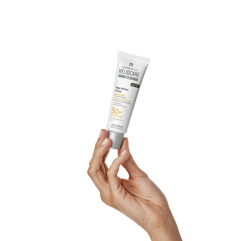 Main tenant un tube de crème solaire. Blanc, avec texte et SPF 50+.