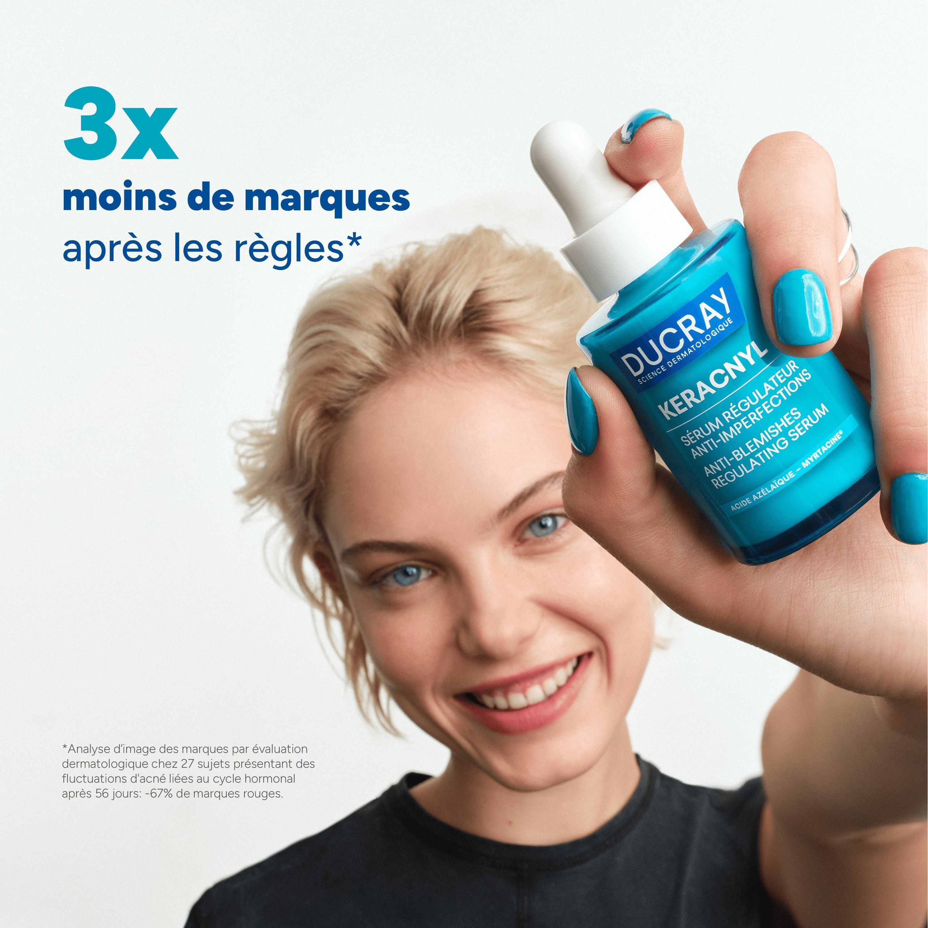 Femme tenant un flacon de sérum Ducray Keracnyl. Texte : 3x moins de marques après les règles.