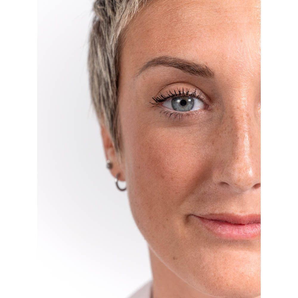 Close-up van een gezicht. Vrouw met blond haar. Mascara aangebracht.