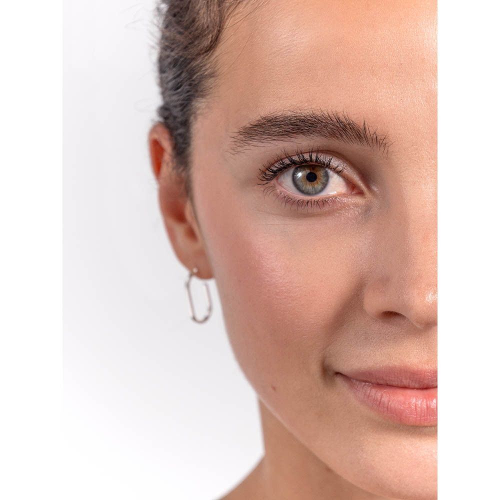 Gros plan sur un visage. Femme aux yeux bruns. Application de mascara.
