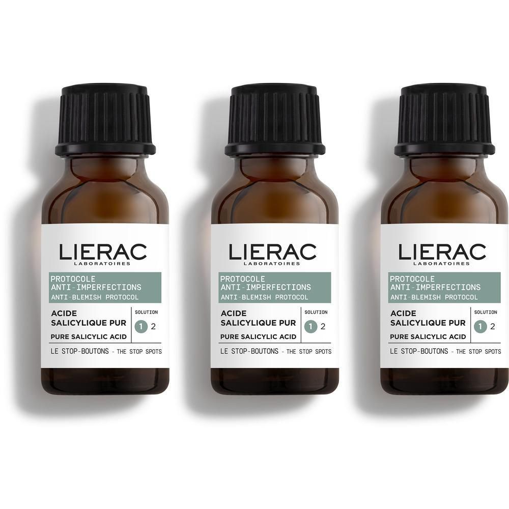 Drie bruine flessen met zwarte dop. Etiket met productnaam en tekst. Merk: Lierac.