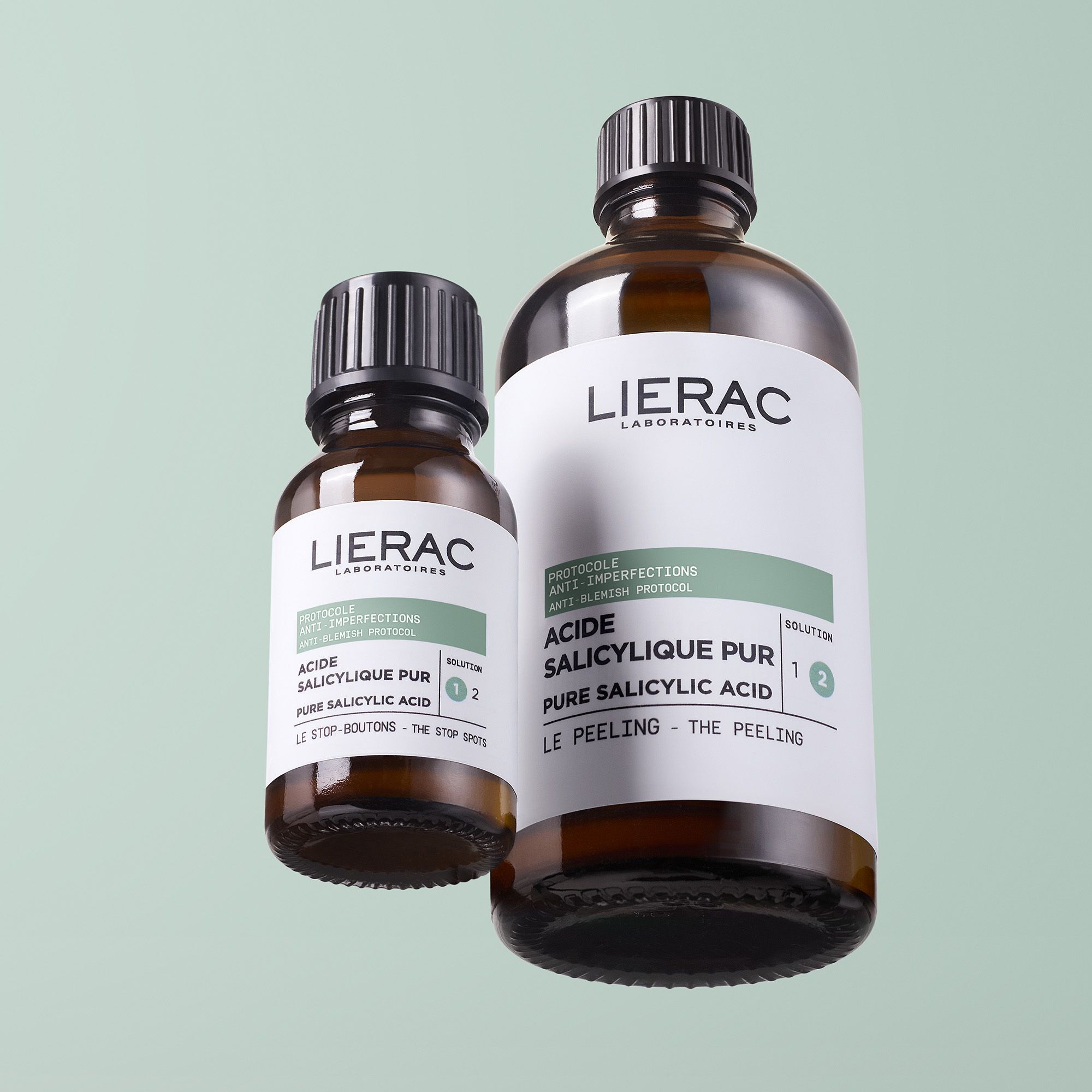 Deux flacons bruns avec bouchon noir. Étiquette avec nom et texte du produit. Marque : Lierac.