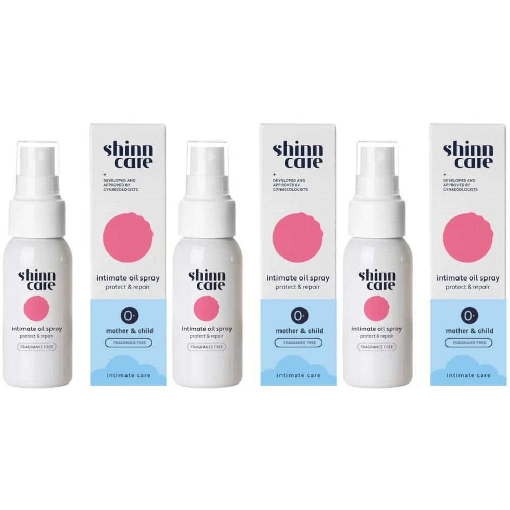 Plusieurs flacons de spray d'huile intime avec emballage. Flacon blanc avec cercle rose et texte. Boîte avec logo et informations.