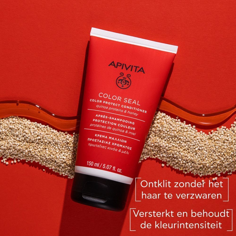Rode tube Apivita Color Seal Après-Shampooing. Opschrift en logo zichtbaar. Quinoa-korrels en honingraat op de achtergrond.