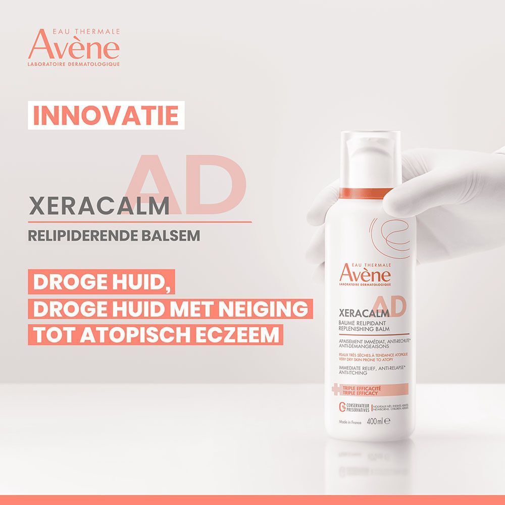 Een hand in een witte handschoen houdt een fles Avène Xeracalm A.D. Baume Relipidant vast. Tekst op de afbeelding.