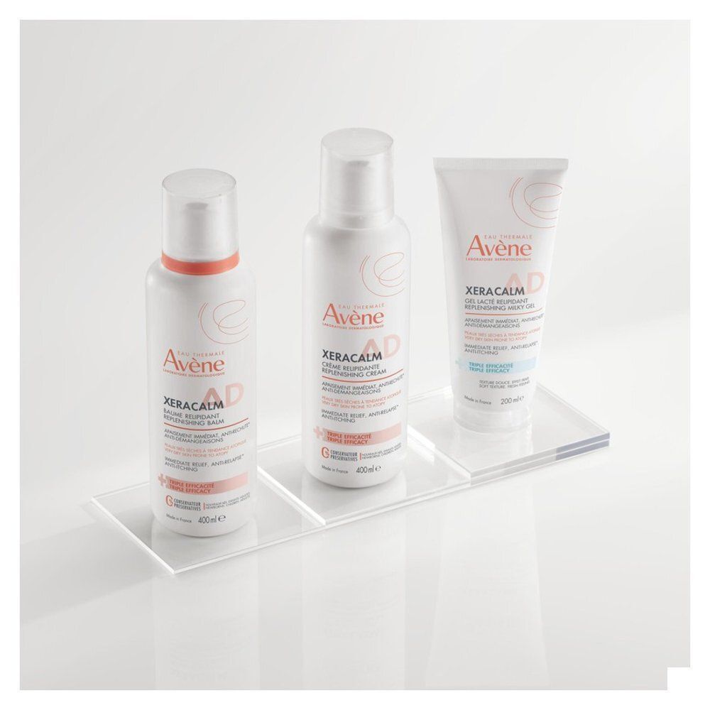 Trois produits Avène Xeracalm A.D. sur une étagère transparente. Différents formats.
