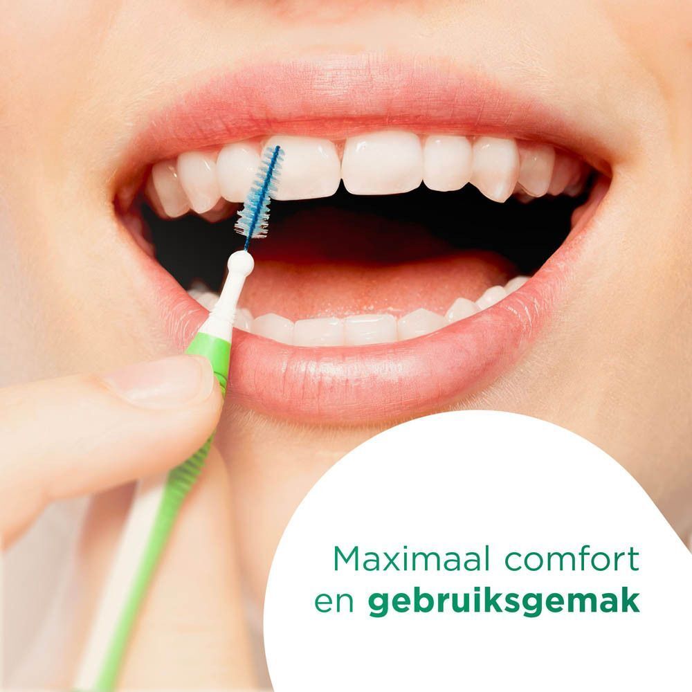 Mond met tanden die worden gereinigd met een groene GUM® TRAV-LER® rager. Blauwe borstelharen.
