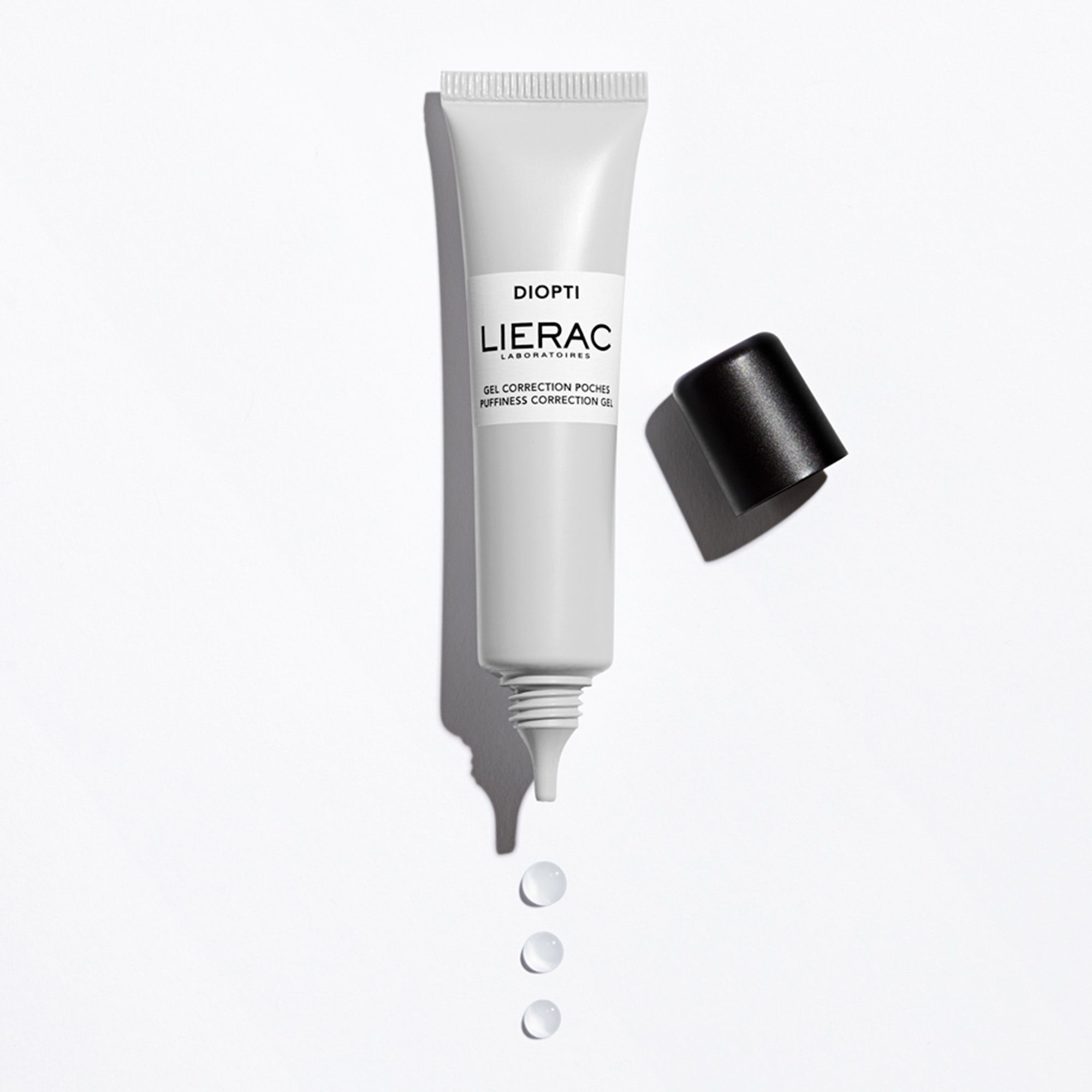 Tube de gel LIERAC Diopti, bouchon à côté. Tube blanc avec bouchon noir. Inscription : DIOPTI, LIERAC, Gel Correction Poches.
