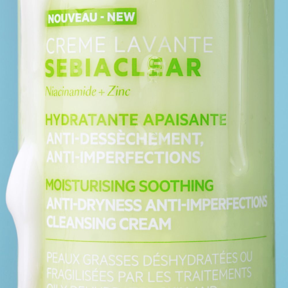 Gros plan sur une bouteille verte avec texte blanc. Le texte indique "SEBIACLEAR Crème Lavante" et "Niacinamide + Zinc".