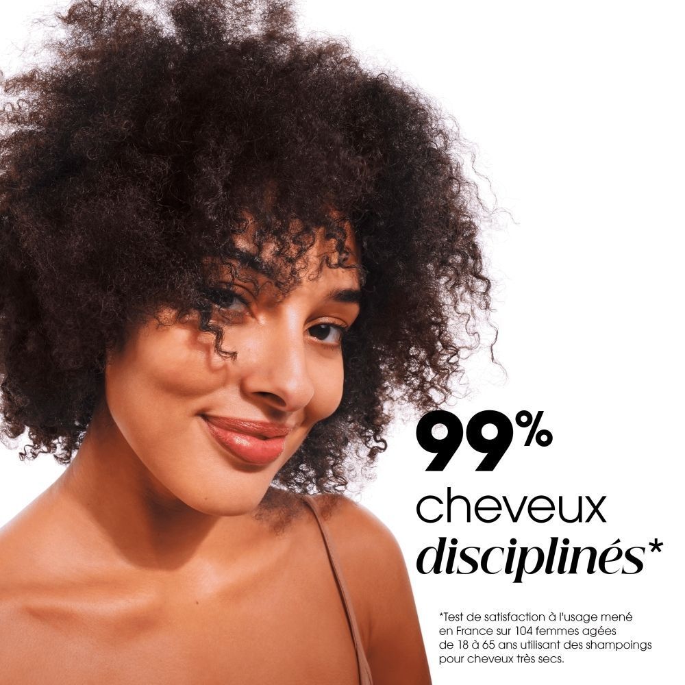 Femme aux cheveux bouclés et volumineux sourit. Texte : 99% cheveux disciplinés.