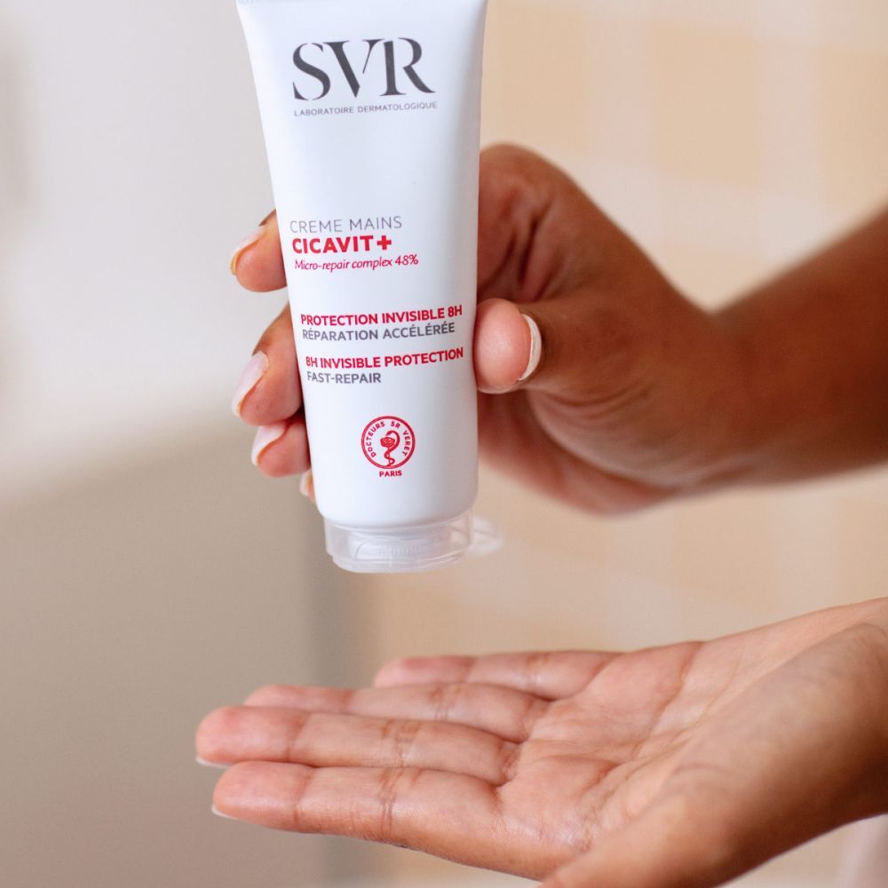 Main tenant un tube de SVR Cicavit+ Crème Mains. Tube tenu au-dessus de la paume ouverte.