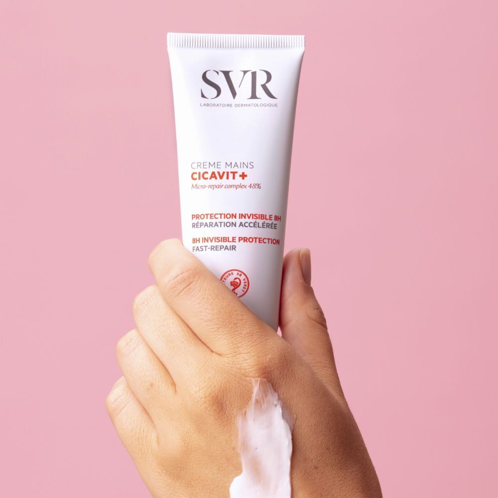 Main tenant un tube de SVR Cicavit+ Crème Mains. Crème appliquée sur la main.